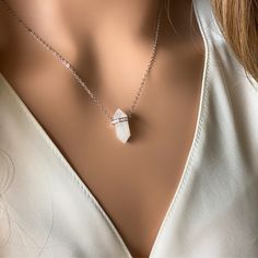 Introducing the Delicate Moonstone Crystal Necklace by Asana Crystals, a mesmerizing piece of jewelry that exudes elegance and enchantment. This stunning crystal necklace features an authentic moonstone crystal point pendant, delicately adorned with sparkling cubic zirconia accents, suspended from a high-quality 925 sterling silver chain. The moonstone crystal necklace is known for its ethereal beauty and its connection to the soothing energies of the moon. Its captivating iridescence reflects a soft glow, creating a sense of tranquility and inner peace. The addition of cubic zirconia adds a touch of glamour and sophistication, making this necklace a perfect accessory for both formal occasions and everyday wear. Delicate Pendant Crystal Necklace With Clavicle Chain, White Sterling Silver Crystal Necklace With Round Pendant, Spiritual White Crystal Jewelry, Silver Moonstone Crystal Necklace, White Moonstone Clavicle Chain Necklace, Crystal Clavicle Chain Necklace As Gift, Crystal Clavicle Chain Necklace For Gift, White Pendant Necklace With Stones, Diamond White Cubic Zirconia Crystal Necklace As Gift