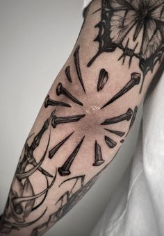 a man's arm with black and white tattoos on it, including an abstract clock