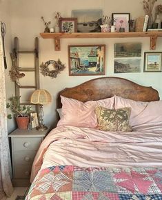 a bed sitting in a bedroom next to a wall with pictures hanging on it's headboard