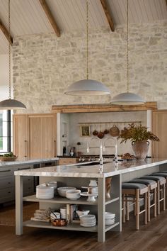 a large kitchen with an island in the middle and lots of stools around it