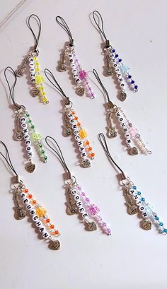 a bunch of different colored beads and charms on a white surface with a keychain