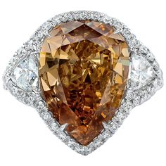 A rare and beautiful engagement ring, featuring a 9.63 carats pear shape diamond certified by GIA as Fancy Deep Brown Orange color and VS1 clarity, set in a four prong setting. Flanked by trillion cut diamonds weighing 1.15 carats total. Accented by a row of round brilliant cut diamonds and a diamond encrusted shank in a half-way setting. Accent diamonds weigh 2.30 carats total. Finely made with a platinum mounting. Size 6.5 US, resizable upon request. Roman Malakov is a custom house, specializi Orange Engagement Ring, Brown Diamond Engagement Ring, White Topaz Engagement Ring, Diamond Platinum Ring, Art Deco Wedding Rings, Platinum Diamond Rings, Chocolate Diamonds, Promise Ring Gift, Beautiful Engagement Rings