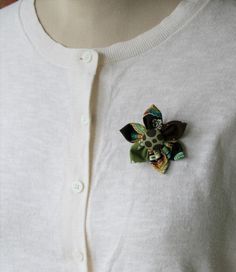 a close up of a person wearing a white sweater with a flower brooch on it