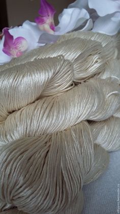 white skeins of yarn with flowers in the background