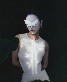 a woman with white makeup and an eye mask