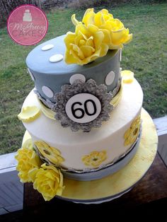 a three tiered cake decorated with yellow flowers and a number 60 on the side