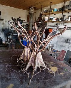 a metal sculpture sitting on top of a wooden table in a room filled with shelves