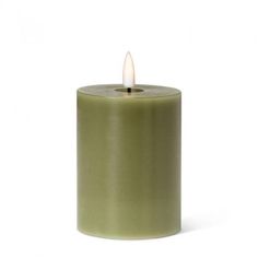 a green candle is lit on a white background