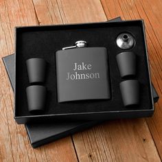 personalized flasks and hip flask set in a black gift box on a wooden table