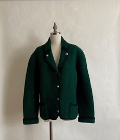 "Gorgeous boiled wool Austrian jacket with black piping and nickel buttons. Jacket is very thick wool with notched lapels and two hip pockets. In excellent vintage condition. Shoulders 19\" across Chest 42\" Waist 39\" Hem 40\" Length from back of neck to hem 25\" Arm Length from shoulder seam to cuff 24.5\" (uncuffed)" Retro Wool Outerwear With Lapel Collar, Vintage Single-breasted Wool Blazer, Retro Winter Blazer With Button Closure, Winter Button-up Wool Tweed Jacket, Winter Wool Button-up Tweed Jacket, Vintage Tweed Jacket With Button Closure For Work, Classic Green Wool Coat, Retro Winter Tweed Jacket With Buttons, Retro Tweed Jacket With Buttons For Winter