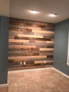 an empty room with wood planks on the wall and flooring in front of it