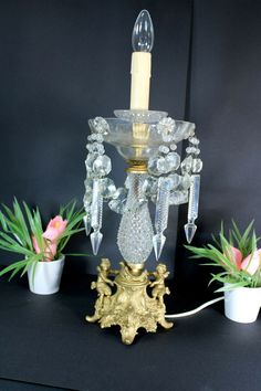 a candle is lit on top of a table with flowers and potted plants in the background