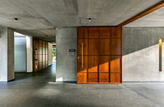 an empty room with wooden doors and concrete walls