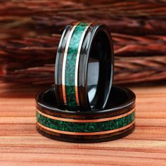 two wedding bands with green and gold inlays