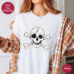 a woman wearing a t - shirt with a skull and crossbones on it