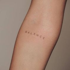 a woman's arm with the word balance tattooed on her left side, in cursive font