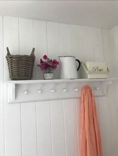 a shelf that has some flowers on top of it and a basket next to it