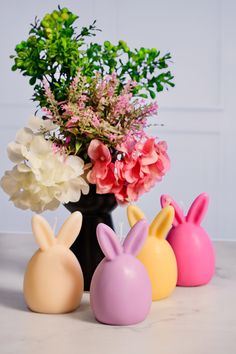 three vases filled with flowers and bunny ears on a counter top next to each other