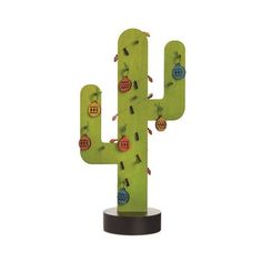 a cactus shaped sculpture with various stickers on it's back and sides, in front of a white background