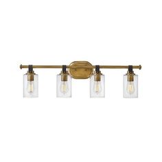 three light bathroom fixture with clear glass jars on the bottom and brass finish, in an antique