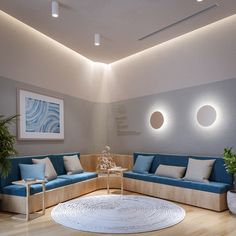 a living room with blue couches and round rugs on the wooden flooring