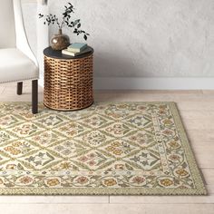 a white chair sitting on top of a wooden floor next to a rug covered in flowers