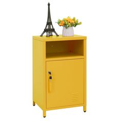 a yellow cabinet with a flower vase and the eiffel tower in the background