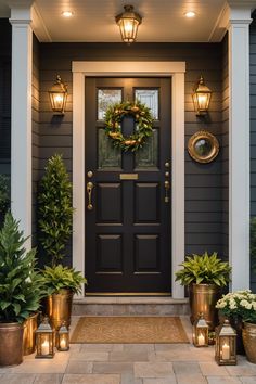 a front door with potted plants and candles