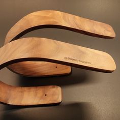 two wooden spoons sitting next to each other on top of a black countertop