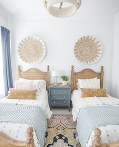 two twin beds in a bedroom with blue and white decor on the wall above them