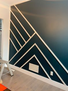 a room painted with blue and white lines on the wall, next to a ladder