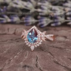 an engagement ring with a blue topazte surrounded by white and pink diamond accents