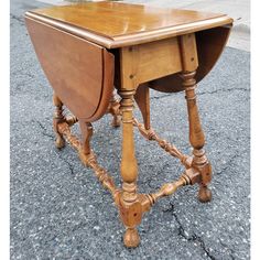 an old wooden table with turned down legs and a drop - leafed top on the bottom