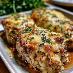 two meatballs covered in cheese and sauce on a plate