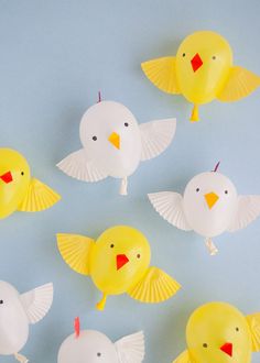 several yellow and white paper birds on a blue background with one bird in the middle