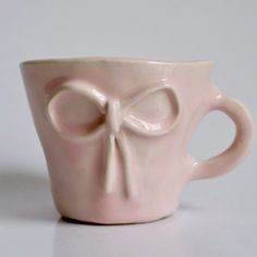 a pink coffee cup with a bow on it