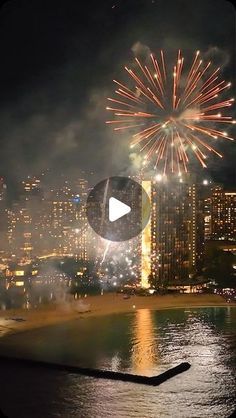 fireworks are lit up over the city skyline at night, with buildings in the background