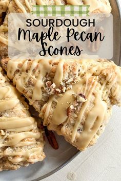 a plate topped with scones covered in frosting and pecans on top of it