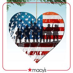 a heart shaped ornament with the american flag and soldiers in silhouette on it