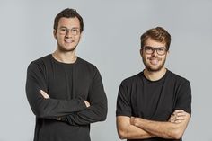 two men standing next to each other with their arms crossed