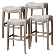 three wooden stools with grey upholstered seat cushions on white backless chairs