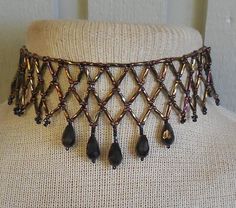 To bead this choker, I did netted weave using twisted, bronze, bugle beads, cocoa brown and black, size 8 and 10, seed beads; and  bronze, faceted, Czech glass drop beads.   Because I added an extender, the length is adjustable; starting at 30.7 cm. (12 1/8"), up to 48 cm. (18 3/4").  It closes with a black, lobster claw clasp. If you would prefer the tail loop up rather than dangle, just let me know at time of purchase, and I can easily add a hook. at at the end. The last photo shows more of my work.   If you don't see the listing in my shop, contact me and, chances are, if I don't have it in stock I can probably make a custom necklace for you. This is a simple version of the amazing collars made by Native-Americans, for centuries, up to the present.  To see some examples, go to the Natio Adjustable Brown Beaded Choker, Brown Adjustable Length Choker Necklace, Traditional Brown Beaded Necklace Hand-strung, Traditional Brown Hand-strung Beaded Necklaces, Brown Oval Beaded Hand-strung Necklaces, Cocoa Brown, Black Seed, Beaded Choker Necklace, Bugle Beads