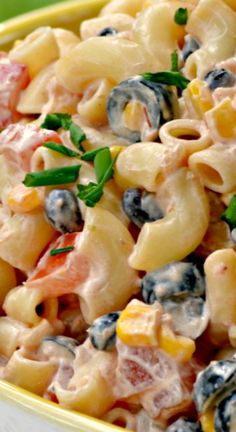 a yellow bowl filled with pasta salad on top of a table