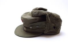 Original Austrian army winter cap Twill shell with insulated, quilted lining Poly-fleece ear flaps snap under chin or above crown Ear holes with snap flaps, stitched brim retains shape Condition: NEW Material: 65% polyester, 35% wool Military Hats For Winter Outdoor Activities, Winter Military Hat For Outdoor Activities, Military Style Winter Hat For Outdoor Activities, Military Style Hat For Streetwear, Military Style Visor Hat For Streetwear, Khaki Military Hats For Streetwear, Adjustable Military Style 5-panel Hat, Brown Military Hat For Winter, Military Visor Hat For Streetwear