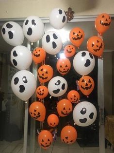 a bunch of balloons that have been decorated with pumpkins and ghost faces on them