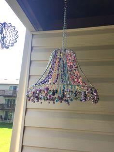 a chandelier hanging from the side of a house in front of a window