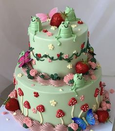 a three tiered cake with strawberrys and butterflies on the top is decorated in pastel green frosting