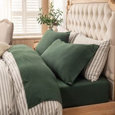 a bed with green and white pillows in a bedroom