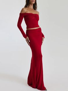 a woman in a red dress posing for the camera with her hands on her hips