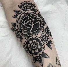 a black and white flower tattoo on the arm